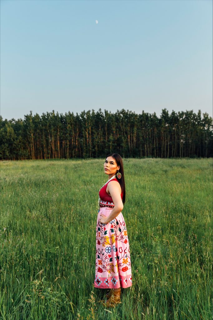 model wearing nipin pink skirt on grass with trees in the background