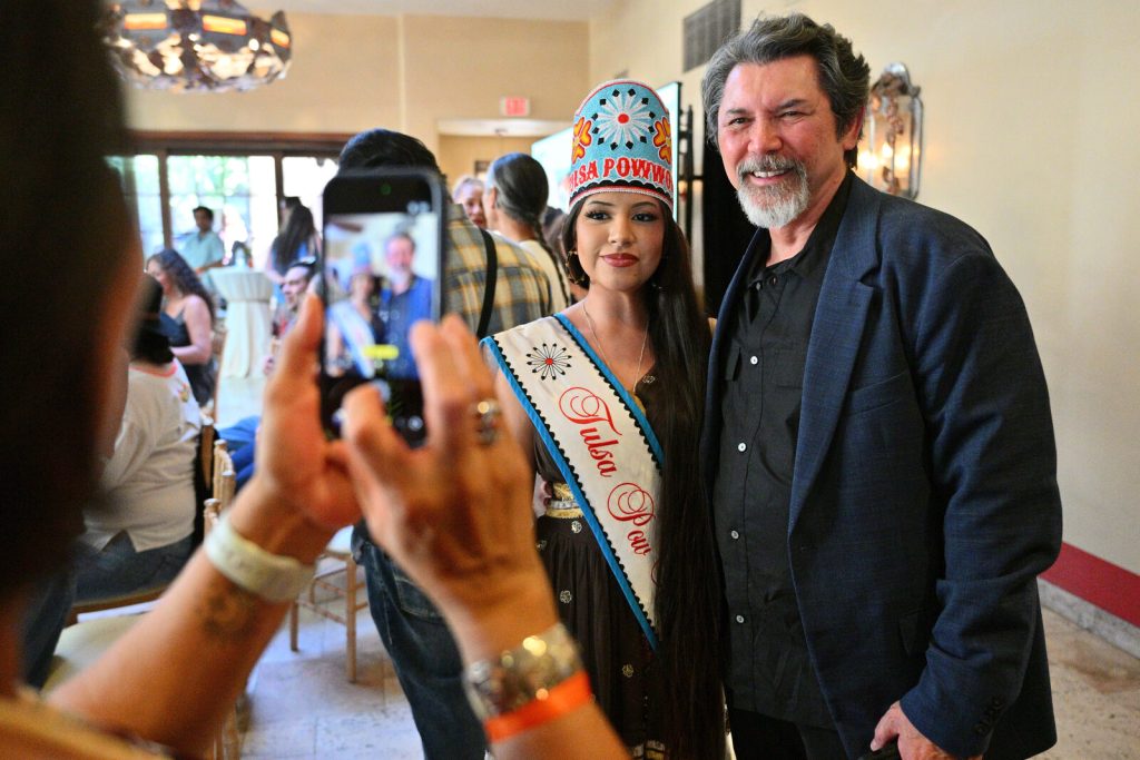 Tulsa Powwow Princess Katie Alexander and actor Lou Diamond Phillips pose before the Gangland film panel