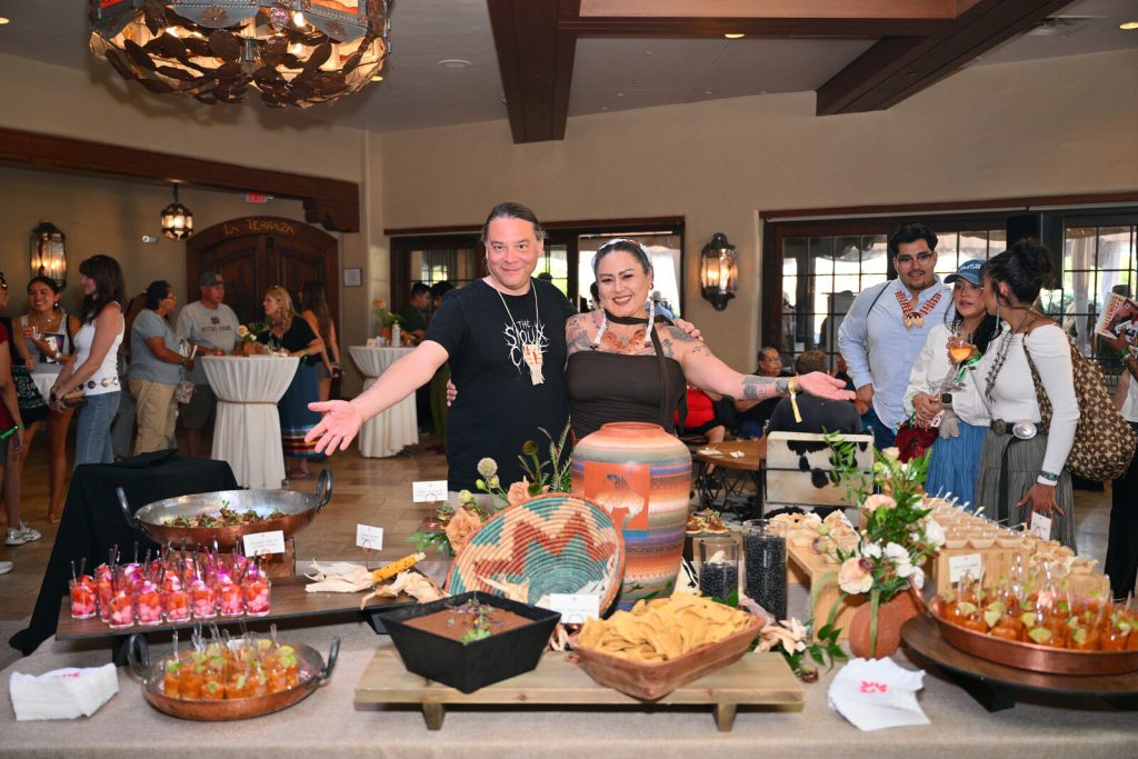 Chef Sean Sherman and Chef Claudia Serrato pose with the menu they prepared for the Rez Roundup Honky Tonk