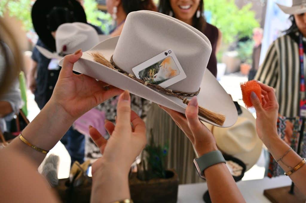 Guests customize cowboy hats at the Indigenous House Indigenous Creator's Summit on August 14, 2026 in Santa Fe, New Mexico.