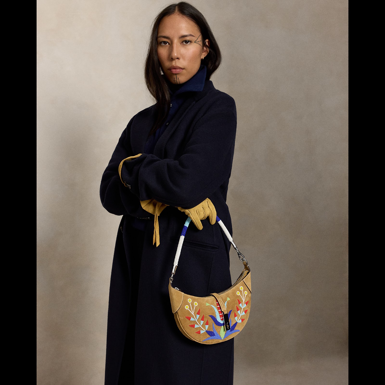 Quannah ChasingHorse holding the beaded Wild Blossom Polo ID Bag.